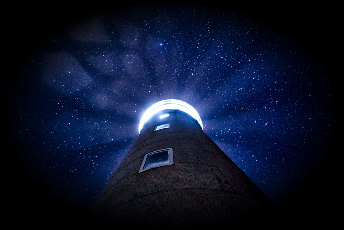 Le faisceau d'un phare sous un ciel étoilé